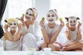 Mom with her daughters making clay face mask