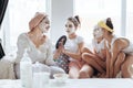 Mom with her daughters making clay face mask