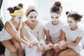 Mom with her daughters making clay face mask