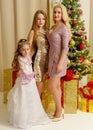 Mom with her daughters near the New Year tree. Royalty Free Stock Photo