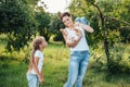 Mom and her daughters are walking in the summer park