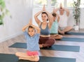 Mom with her family practices yoga in lotus position