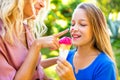 Mom with her kid baby eating ice cream in park and smiling in tropical beach Royalty Free Stock Photo