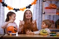 Mom and her kids are getting ready for Halloween. The boy and the girl painted scary faces on the pumpkins, and the