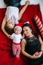 Mom and her little children on bed in bedroom. Happy New Year and Merry Christmas. Top view Royalty Free Stock Photo