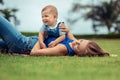 Mom and her little smiling son play together, lying on the lawn Royalty Free Stock Photo