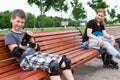 Mom and her son resting on the beanch during roller skating together