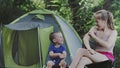 Mom and her son to itching after mosquito bites sitiing near tent