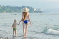 Mom and his little son are walking along the sea coast. Back vie Royalty Free Stock Photo