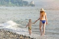 Mom and his little son are walking along the sea coast. View from the back Royalty Free Stock Photo