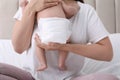 Mom holding her baby in diaper at home, closeup Royalty Free Stock Photo