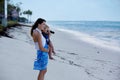 Mom, holding little toddler boy with binoculars, observing dolphins