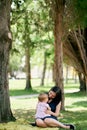 Mom holds on her lap a little girl sitting on a blanket on the lawn Royalty Free Stock Photo