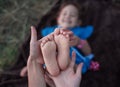 Mom holds her little daughter `s feet. White feet with gentle skin