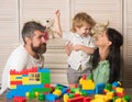 Mom holds son near toy construction bricks and plush toys. Royalty Free Stock Photo