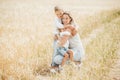 Mom hugging and loving her little kids in wheat field. Happy mother and her children spending time together outdoors