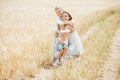 Mom hugging and loving her little kids in wheat field