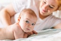 Mom hugs her newborn baby in bed. Four month old baby. Baby care, tenderness, motherhood Royalty Free Stock Photo