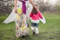 Mom hugs kisses daughter in the lush spring garden