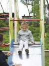 Mom insures her daughter when she comes down from the children slide