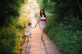 Mom keeps daughter's hand and walks the walk on the nature in sunset light Royalty Free Stock Photo