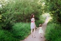 Mom keeps daughter's hand and walks the walk on the nature in sunset light Royalty Free Stock Photo