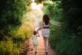 Mom keeps daughter's hand and walks the walk on the nature in sunset light Royalty Free Stock Photo