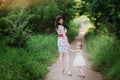 Mom keeps daughter's hand and walks the walk on the nature in sunset light Royalty Free Stock Photo