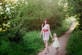 Mom keeps daughter's hand and walks the walk on the nature in sunset light Royalty Free Stock Photo