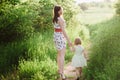 Mom keeps daughter's hand and walks the walk on the nature in sunset light Royalty Free Stock Photo