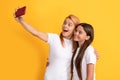 mom and kid blogging. happy woman and girl take selfie with mobile phone. selfie family