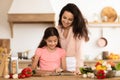 Mom and kid daughter looking through recipe book in kitchen Royalty Free Stock Photo