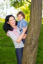 Mom and kid hide behind tree and having fun Royalty Free Stock Photo