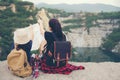 Mom and kid holding maps and travel backpacks sitting victorious facing on the grand canyon Royalty Free Stock Photo