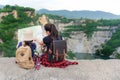 Mom and kid holding maps and travel backpacks sitting victorious facing on the outdoors grand canyon for education nature.