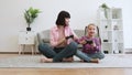 Mom and kid with joypads showing winner's gesture indoors