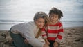 Mom kid playing sand beach closeup. Smiling parent having fun kissing cute son Royalty Free Stock Photo