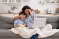 Mom and kid son with bowl of popcorn watching scary movie closing their eyes sitting on sofa at home Royalty Free Stock Photo