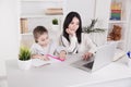 Mom and kid using laptop together and teaching in internet. Royalty Free Stock Photo