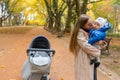 Mom kisses her baby while holding in arms while walking in the park. Royalty Free Stock Photo