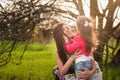 Mom kisses and hugs daughter on nature, family, motherhood, child