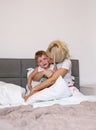 Mom kisses and hugs son in the bedroom Royalty Free Stock Photo