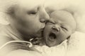 Mom kisses a newborn baby, vintage photo with toning Royalty Free Stock Photo