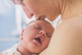 Mom kisses a sleeping baby on the head lying with an open mouth on his chest Royalty Free Stock Photo