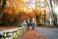 Mom leads by the hand a little girl walking along a stone fence walking with dad along the road in the park Royalty Free Stock Photo