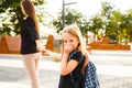 Mom leads her daughter to school. Return to school. Woman and girl with backpack behind the back. Beginning of lessons Royalty Free Stock Photo