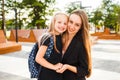 Mom leads her daughter to school. Return to school. Woman and girl with backpack behind the back. Beginning of lessons Royalty Free Stock Photo