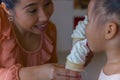 Mom and little child eating ice scream cone together . feeling enjoyment