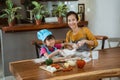 Mom and little cute girl in chef clothes making homemade pizza Royalty Free Stock Photo