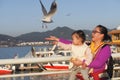 Mom And Little Daughter Feeding Black-headed Gull